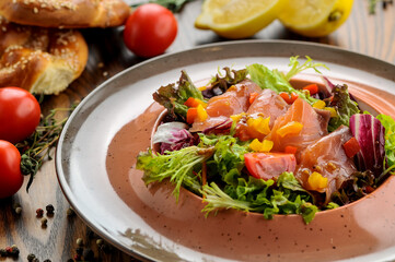 fresh salad with tuna, tomatoes and sauce in a deep round plate
