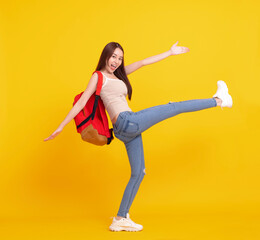 Happy student girl walking and celebrating  isolated over yellow