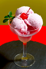 Round balls of sweet ice cream in a glass on a colored background