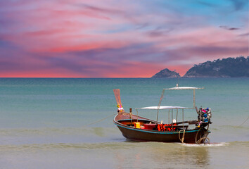 Long tail Boat on colourful sunset over a Beach in Phuket Thailand