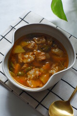 a bowl of beef cooked in spicy soup named asem asem in Bahasa 