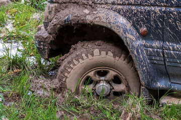 Fototapeta na wymiar Off-road vehicle stuck in the mud. Dirty offroad car in swamp. Adventure travel concept. 4x4 SUV got bogged. Journey, tourism concept.