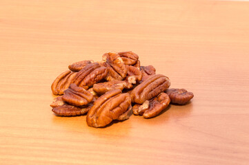 Pecan nut halves on wooden table.