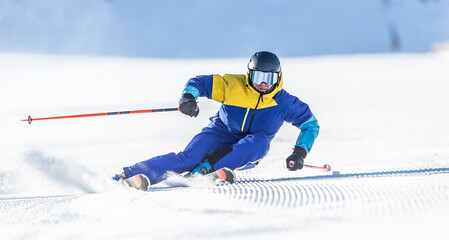 A young aggressive skier on an alpine slope demonstrates an extreme carving skiing style. - obrazy, fototapety, plakaty