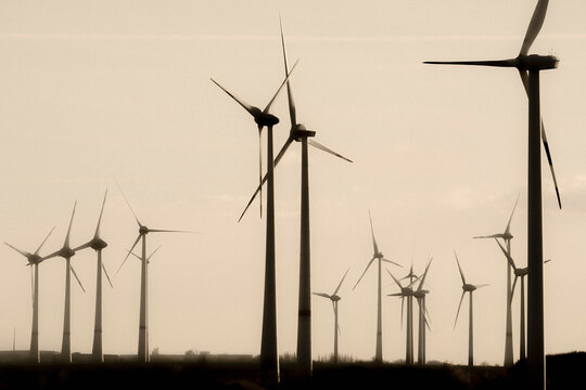 Wind turbine farm against sunset sky, Germany
