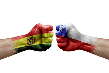 Two hands punch to each others on white background. Country flags painted fists, conflict crisis concept between bolivia and chile