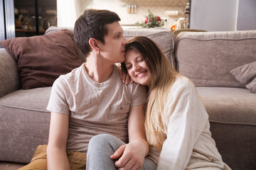 Obraz premium family has fun spending time together at home. a loving couple sitting on the floor hugging and having fun together at home