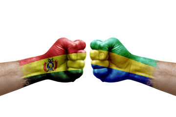 Two hands punch to each others on white background. Country flags painted fists, conflict crisis concept between bolivia and gabon