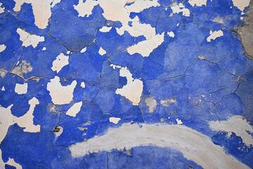 A damages, and very weathered blue painted house wall in Spain.