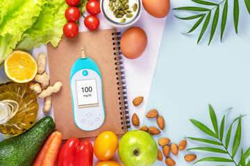 Concept of no diabetes and control of glycemia with a diet. Organic vegetables and fruits, olive oil and glucometer with the result of good glycemia on a blue background with copy space