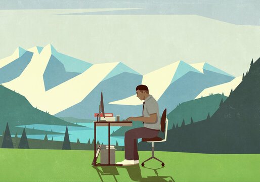 Businessman working at desk in idyllic mountain meadow
