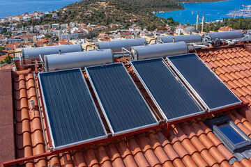 Solar water heater installed on tile roof of house for eco heating of water. Large water tanks. Horizontal photo.