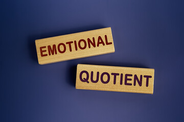 The words Emotional quotient is written on a wooden blocks on a dark blue background. Concept text