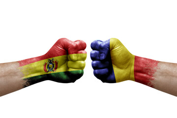 Two hands punch to each others on white background. Country flags painted fists, conflict crisis concept between bolivia and romania