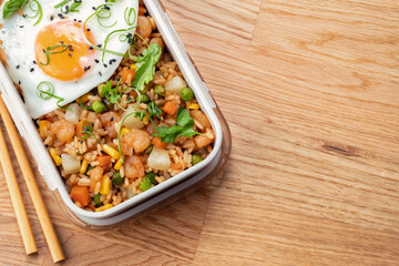 Shrimp fried rice with vegetables and fried egg in a lunch box