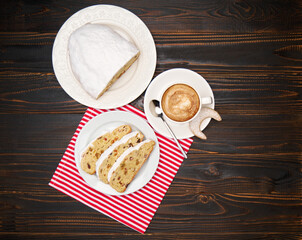 Slices of Traditional Christmas stollen cake with marzipan and dried fruit and cup of coffee