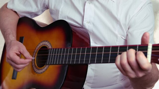 closeup male hands, middle-aged man plays acoustic guitar music, teacher teaches how to play musical instrument, blogger performance, concept of unique bard song