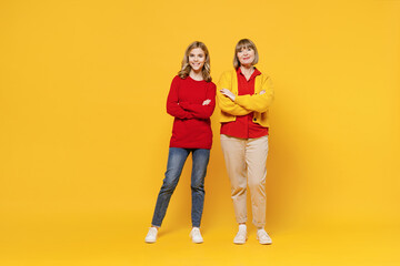 Full body smiling happy cool woman 50s in red shirt have fun with teenager girl 12-13 years old....