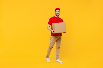 Full body smiling happy delivery guy employee man in red cap T-shirt uniform workwear work as...