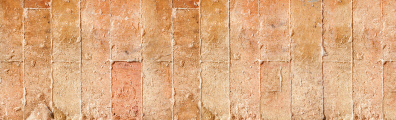 Old traditional, red, sandstone wall in Italy during sunny day
