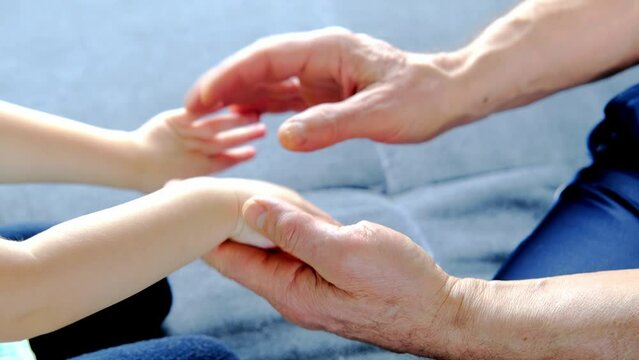 adult male hands holding kid hands, Family Help Care Concept, small hands in fathers hand, touching moment, touch of child and old man, grandfather, parents and child, adopted children, adoption