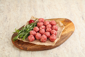 Raw uncooked beef meatballs served rosemary