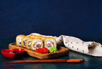 Fried tempura sushi rolls set selective focus with copy space. Japanese traditional fusion food...