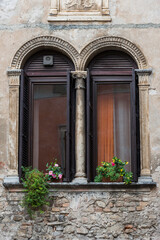 Fototapeta na wymiar Dekorierter Fensterbogen an einer Hausfassade am Gardasee, Italien