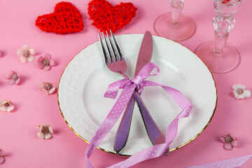 Valentine's day romantic dinner with red hearts on pink background.