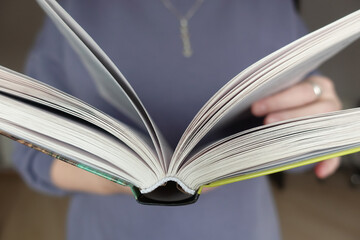 Girl holding an open book in front of her