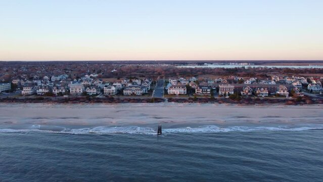 Aerial drone shot, flying along the beach during the golden hour in Cape May New Jersey, Cape May County.
