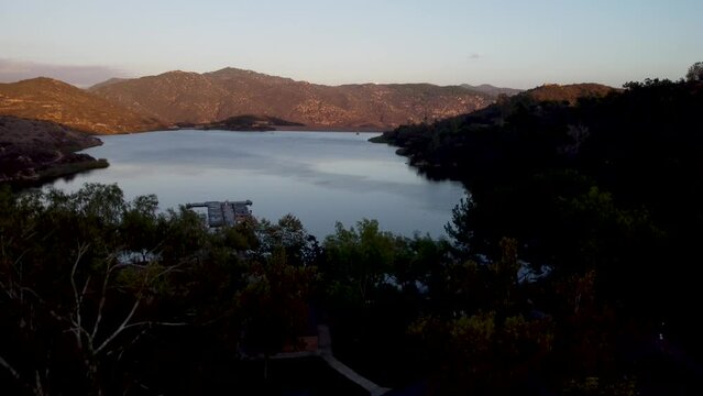 A stunning aerial reveal shot with a drone ascending at Dixon Lake with crystal clear water in Escondido, California