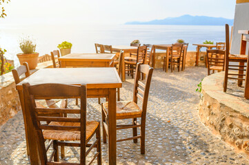 Fototapeta na wymiar Sunny scene Traditional outdoor cafe in a Greek resort. summertime in mediterranean. famous travel destination