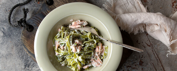 plate of tagliatelle pasta with salmon on the table