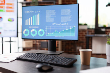 Close up of monitor with company data analysis on screen in empty office. Computer with business...