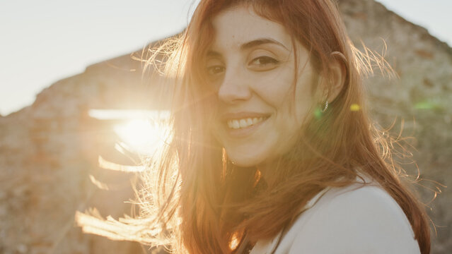 Beautiful girl with white dress explores an ancient Italian castle at sunset
