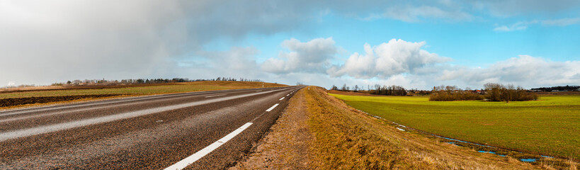 Empty road asphalt landscape among green spring meadows , blue sky,white clouds.Panoramic view,banner.