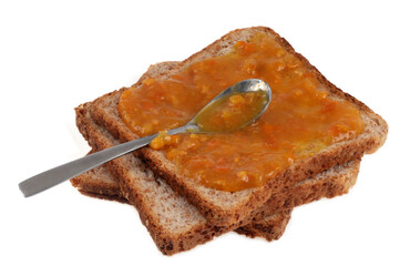 Tranches de pain de mie avec de la confiture de clémantines et une cuillère sur fond blanc