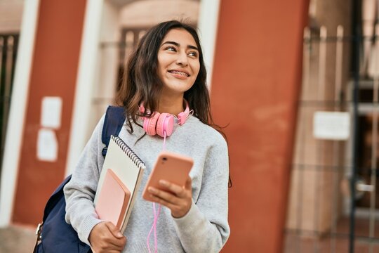 Young middle east student girl smiling happy using smartphone at the city.