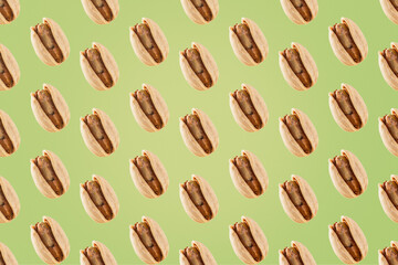 Pattern of roasted pistachios on light green background.