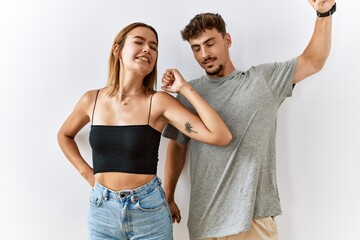 Young beautiful couple standing together over isolated background stretching back, tired and relaxed, sleepy and yawning for early morning