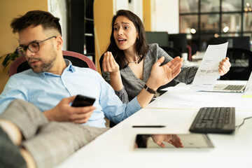 Colleagues arguing in office. Angry businesswpman yelling at her collegue..