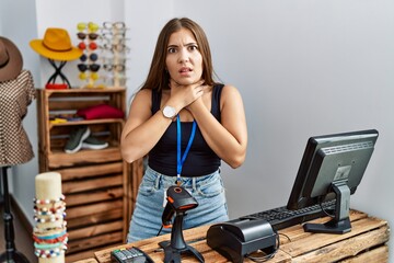 Young brunette woman holding banner with open text at retail shop shouting suffocate because...