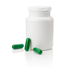 White pills bottle and green capsules