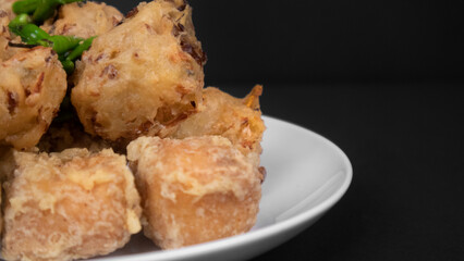 close up variation of indonesian fritters in a black background