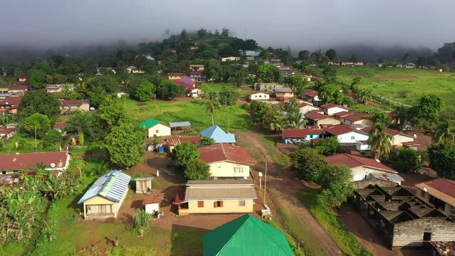 Aerial rural village mountain forest jungle Sierra Leone. Sierra Leone on coast of west Africa suffers extreme poverty hunger. Congested crowded homes businesses. Tropical climate jungle bush forest.