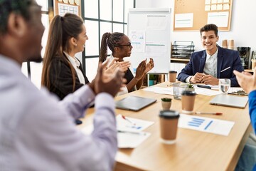 Group of business workers smiling and clapping to partner at the office.