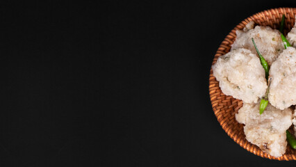 half cut out a bowl of fried tapioka flour in a black background