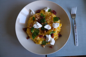 Fresh cooked risotto with pumpkin and goat cheese. healthy and homemade cooking food concept