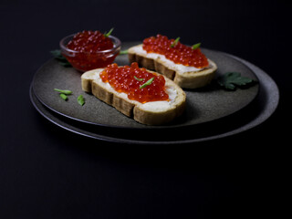 sandwiches with red caviar on a black background